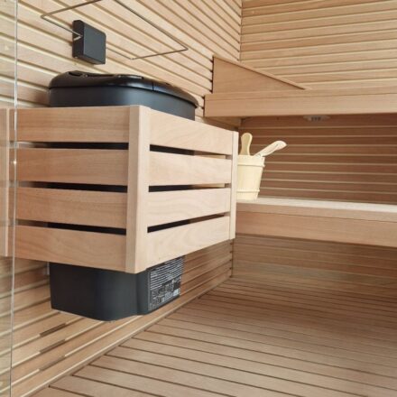 PARTICOLARE INTERNO DI SAUNA CON STUFA NERA E PROTEZIONE SOPRA STUFA