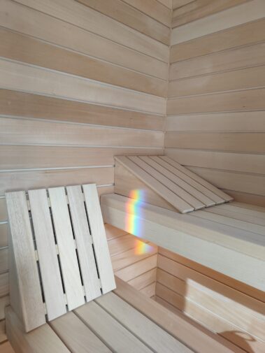 Pane in legno per sauna con sedile e pannelli, atmosfera rilassante e naturale.